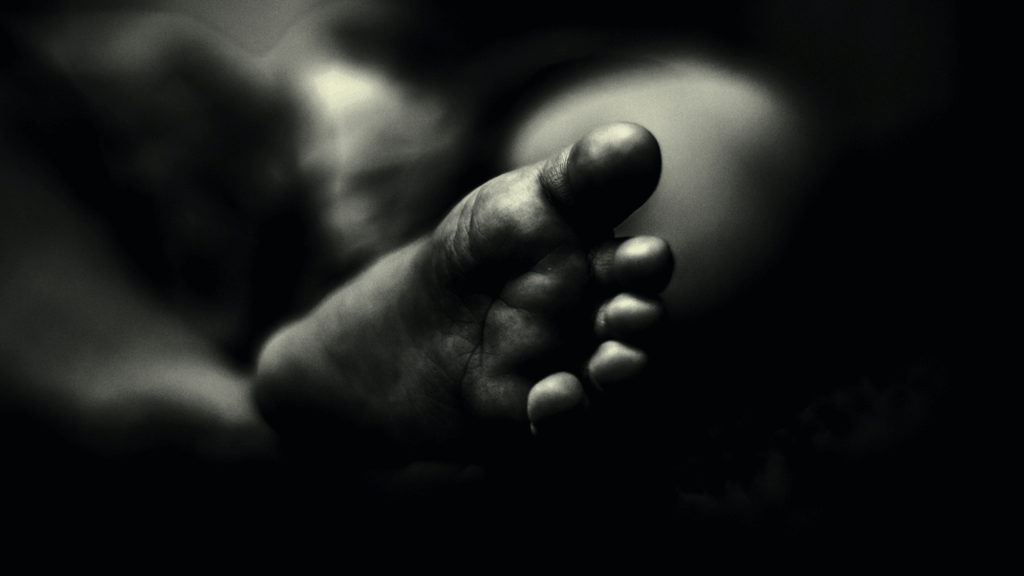 Black and white image of a child's foot.