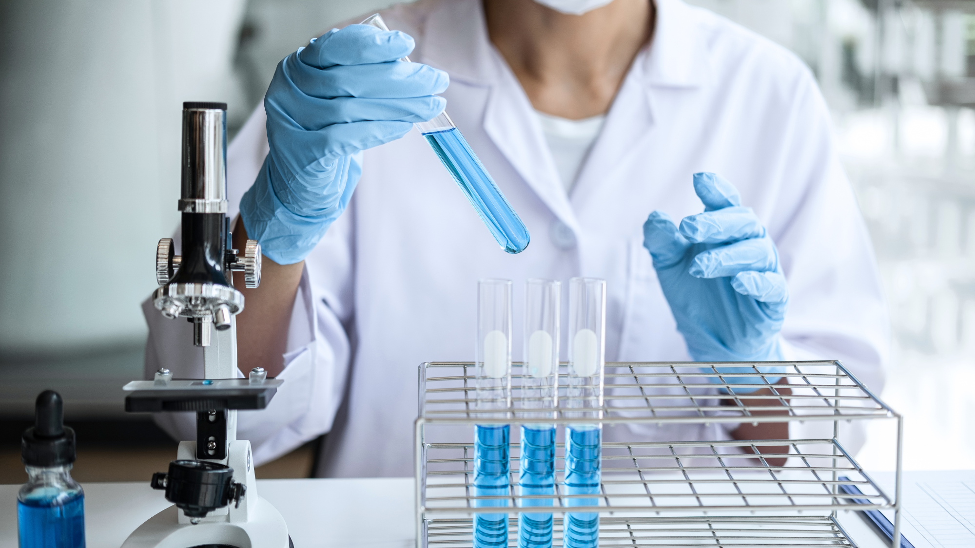 A lab technician handling test tubes in a laboratory.