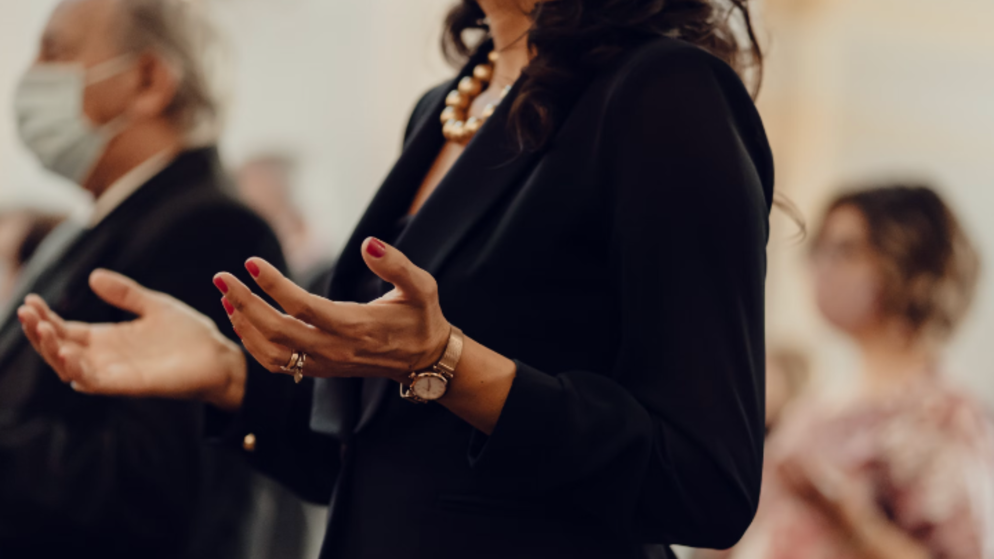 A woman with her hands up in prayer.
