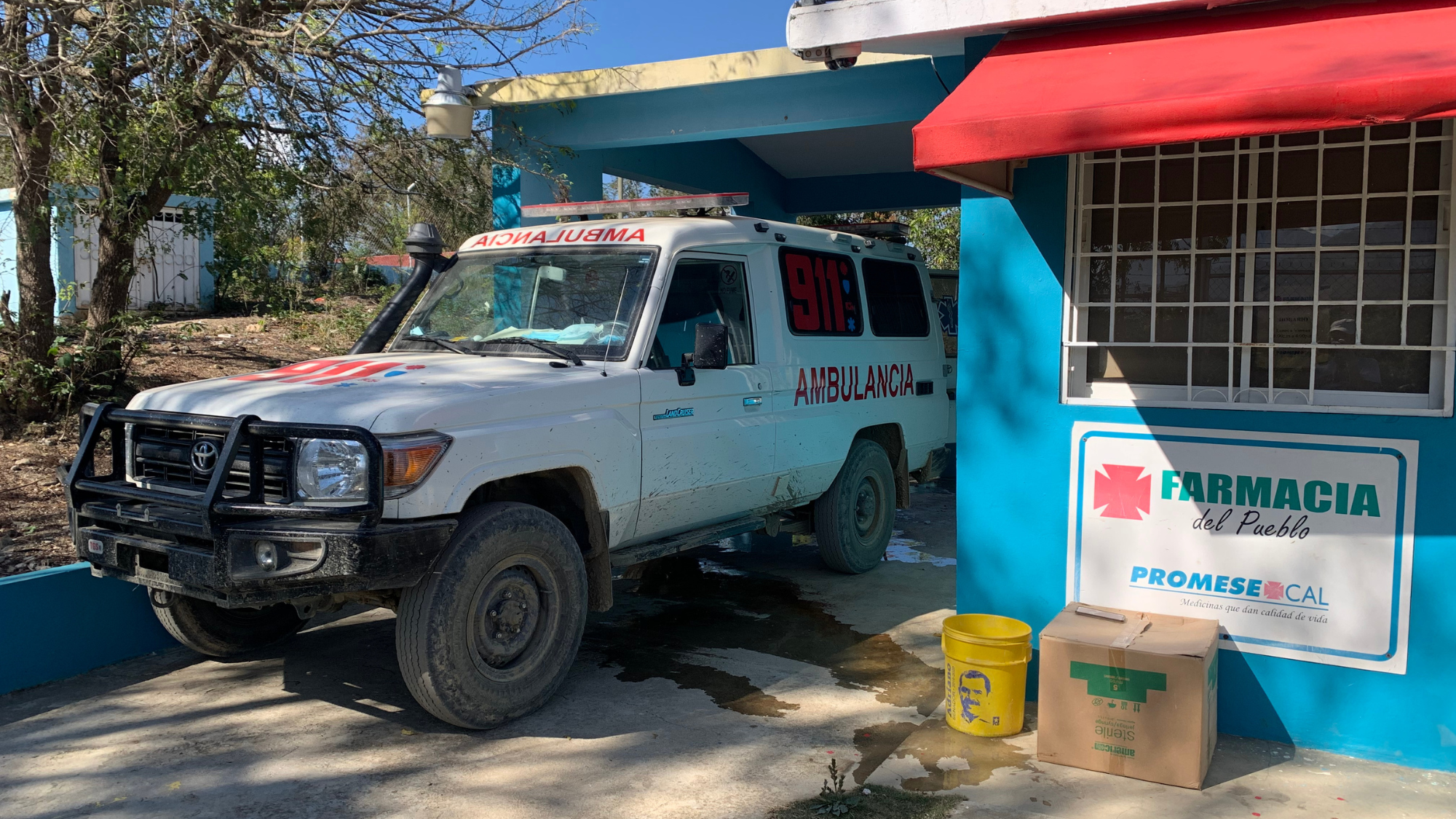An ambulance parked outside a small local pharmacy.