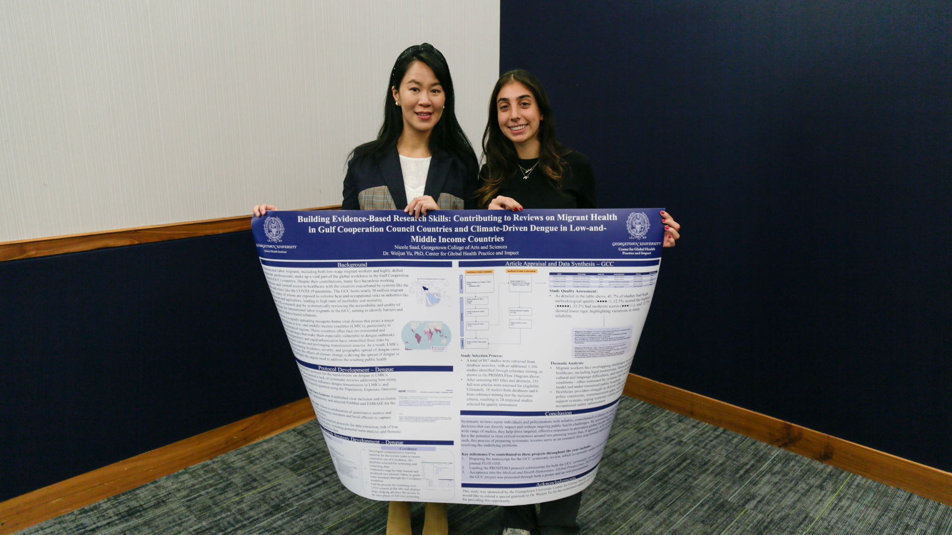 Two presenters holding their poster on migrant health and climate-driven Dengue.