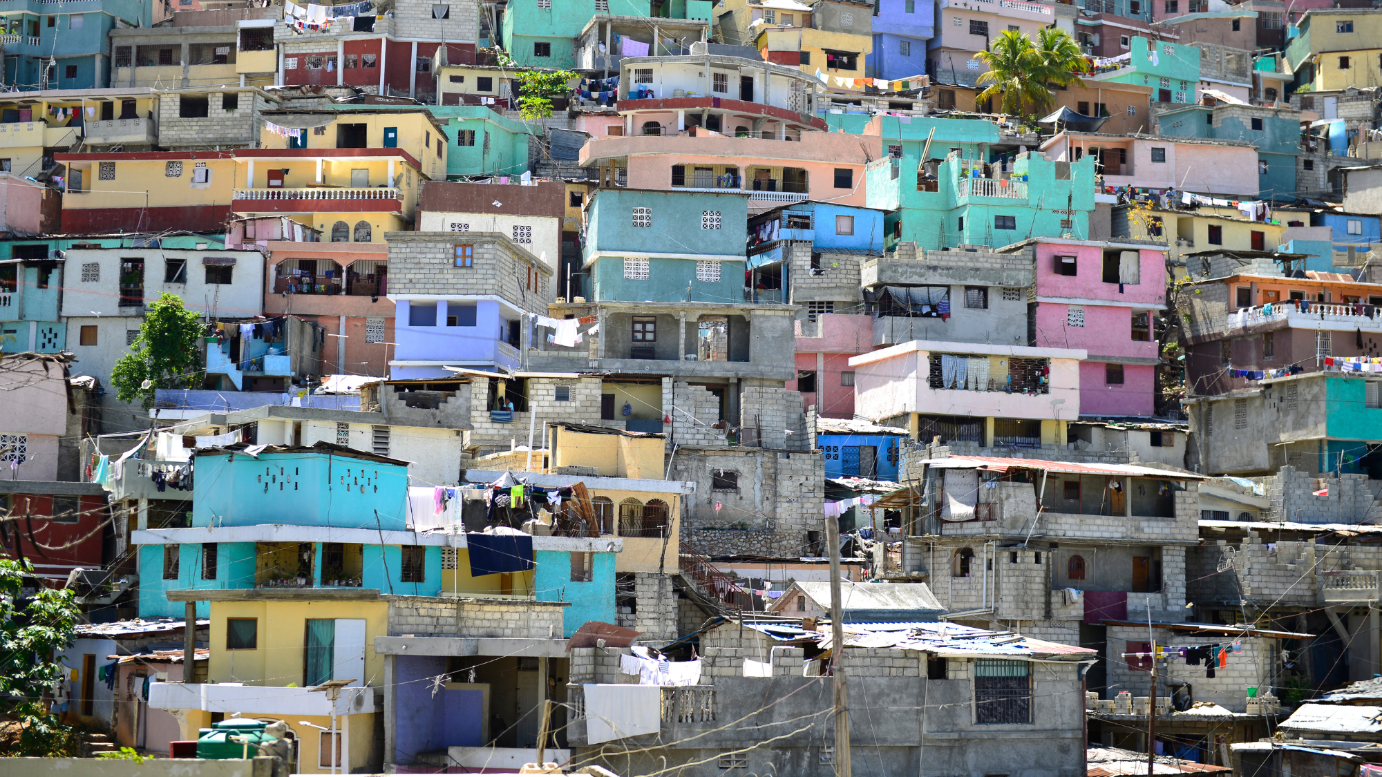 A densely packed residential area with multi-colored concrete block houses.