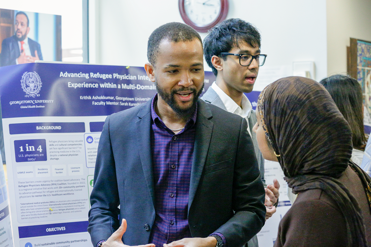 A poster presentation with multiple people presenting
